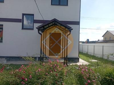 Навес для загородного дома с двускатной крышей из металлочерепицы и водосточной трубой