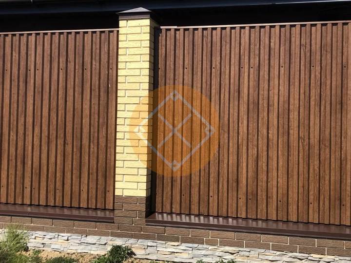 забор из профнастила под дерево с белыми столбами из облицовочного кирпича