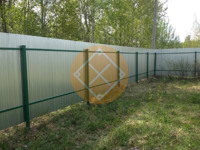 Забор из оцинкованного гофролиста с зелеными столбами и лагами