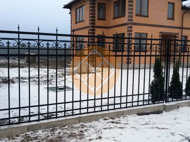 металлический забор черного цвета с небольшими элементами ковки